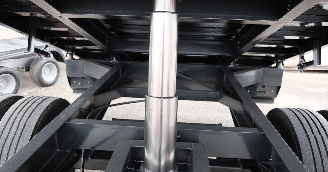 A focus shot of a pristinely clean silver and black hydraulic lifting system, holding up the trailer of a truck.