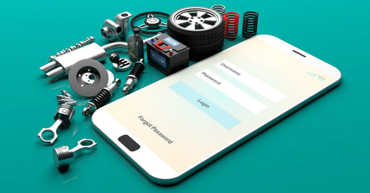 Various model car parts placed beside a smartphone displaying a log-in screen against a teal background.